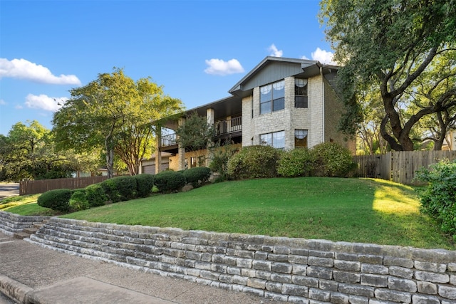 view of front of property with a balcony and a front lawn