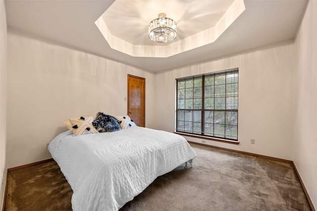 carpeted bedroom featuring a tray ceiling