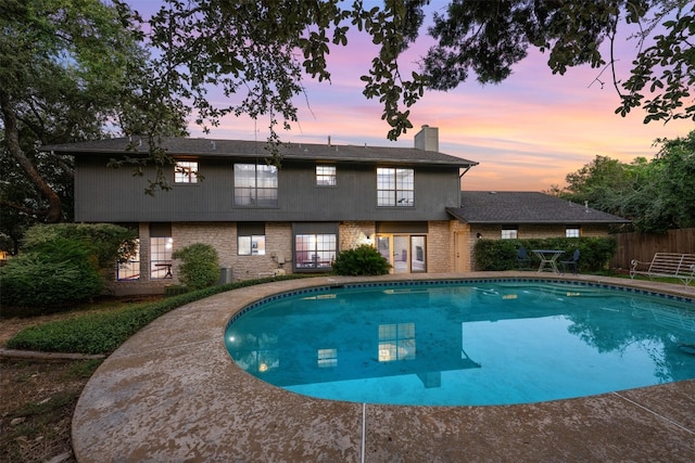 view of pool at dusk