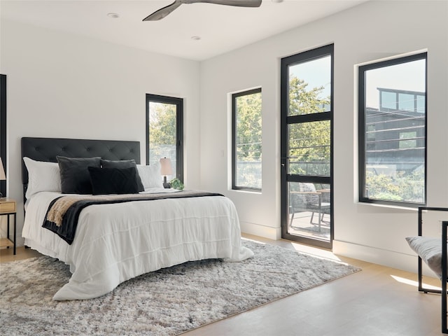 bedroom featuring access to outside, multiple windows, ceiling fan, and light hardwood / wood-style flooring