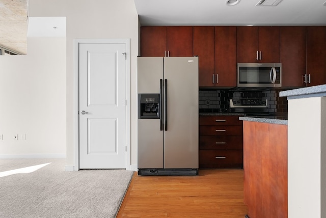 kitchen featuring tasteful backsplash, light hardwood / wood-style flooring, and stainless steel appliances