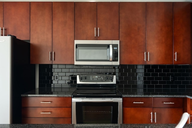 kitchen featuring dark stone countertops, tasteful backsplash, and stainless steel appliances