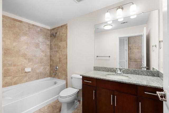 full bathroom featuring tiled shower / bath combo, vanity, tile patterned flooring, and toilet