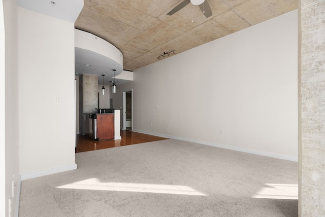 unfurnished room with ceiling fan and carpet