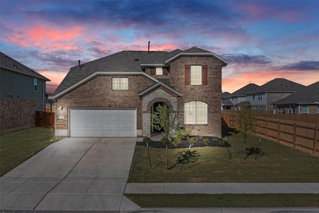 front facade featuring a garage and a lawn