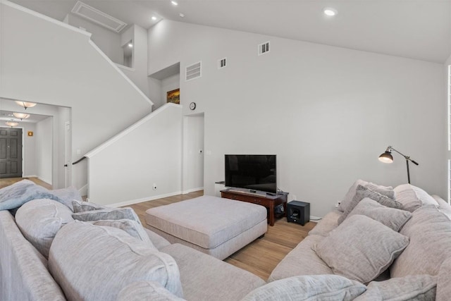 living room with light hardwood / wood-style flooring and high vaulted ceiling