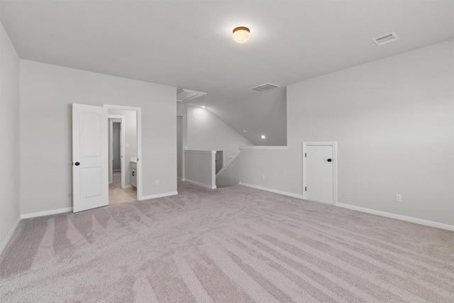 bonus room with light colored carpet and vaulted ceiling