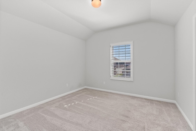 carpeted spare room with lofted ceiling