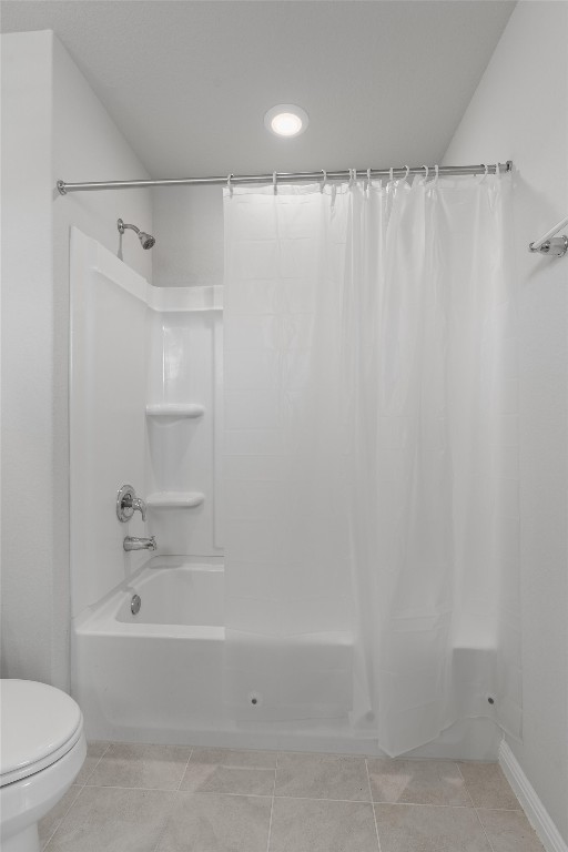 bathroom featuring toilet, tile patterned floors, and shower / bathtub combination with curtain