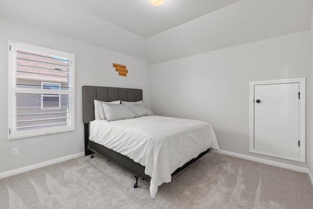 bedroom featuring lofted ceiling and light carpet