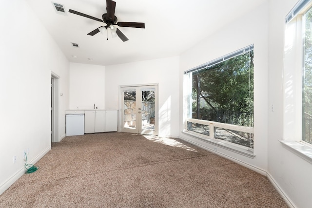 spare room with carpet floors, baseboards, visible vents, and french doors