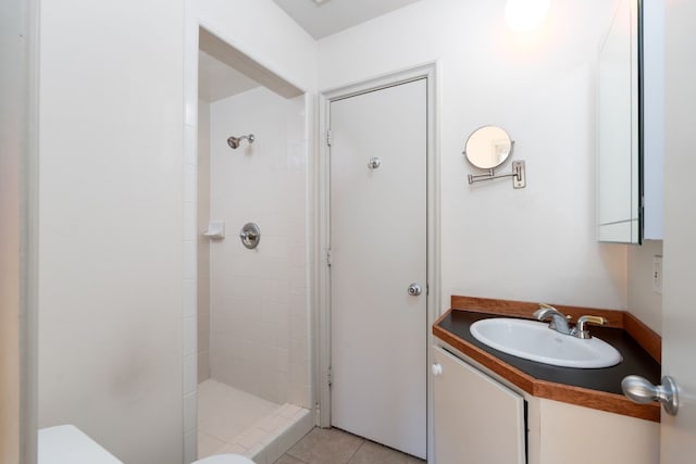 bathroom featuring vanity, a shower stall, toilet, and tile patterned floors