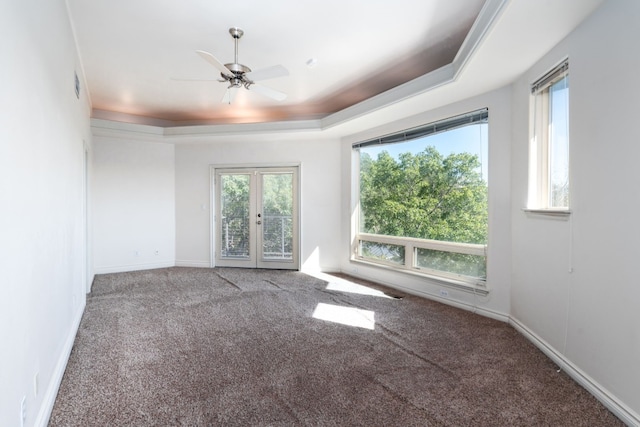 carpeted spare room with french doors, a raised ceiling, visible vents, ceiling fan, and baseboards