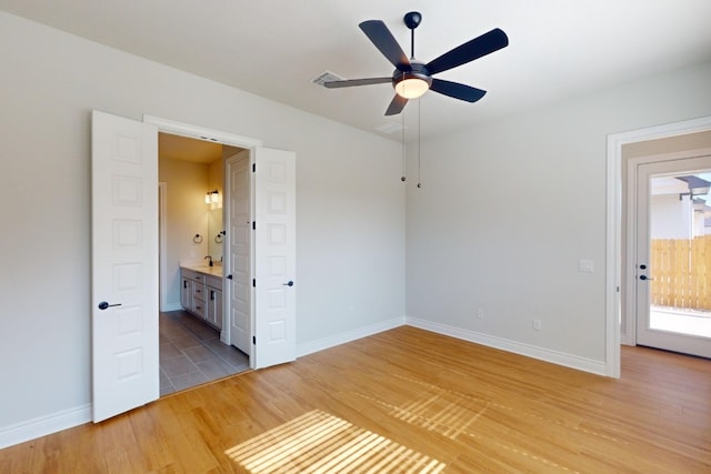 unfurnished bedroom with wood-type flooring, connected bathroom, and ceiling fan