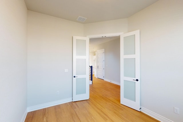 unfurnished room featuring hardwood / wood-style floors and french doors