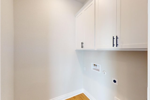 washroom with electric dryer hookup, light hardwood / wood-style flooring, cabinets, and washer hookup