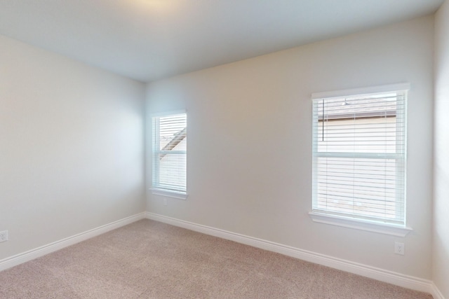 empty room with light colored carpet and a wealth of natural light