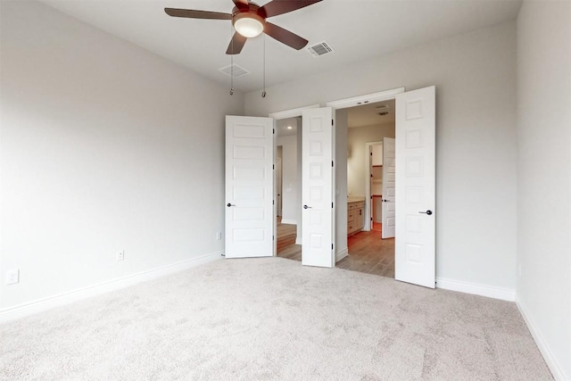 unfurnished bedroom featuring light carpet and ceiling fan