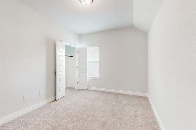 empty room with light carpet and lofted ceiling