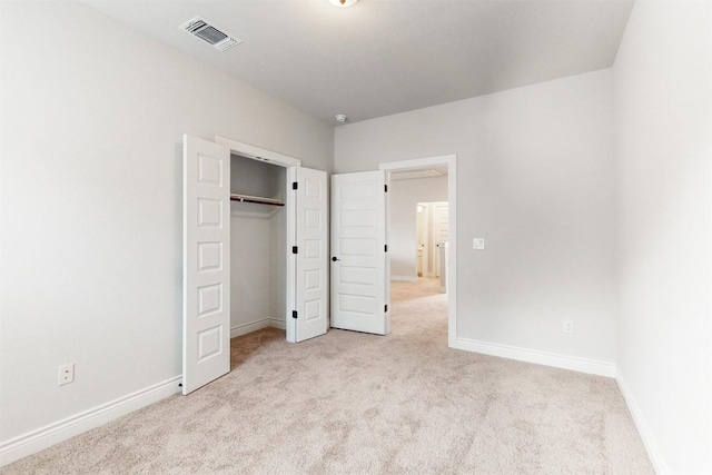 unfurnished bedroom featuring light carpet and a closet