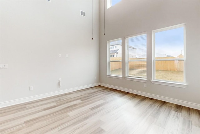 unfurnished room featuring light hardwood / wood-style floors and plenty of natural light