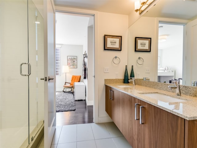 bathroom with wood-type flooring, vanity, and an enclosed shower