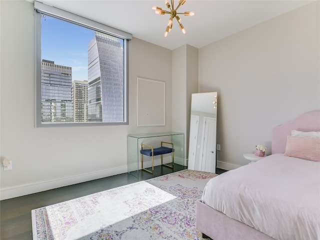 bedroom with dark hardwood / wood-style floors and a notable chandelier