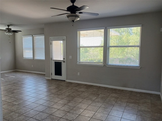 tiled spare room featuring ceiling fan