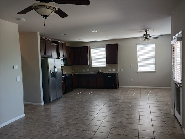 kitchen with dark brown cabinetry, light tile patterned flooring, black appliances, and a wealth of natural light