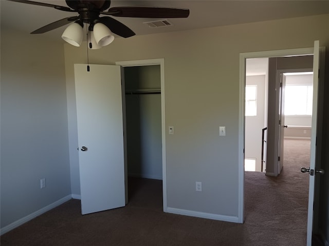 unfurnished bedroom with a closet, ceiling fan, and dark colored carpet