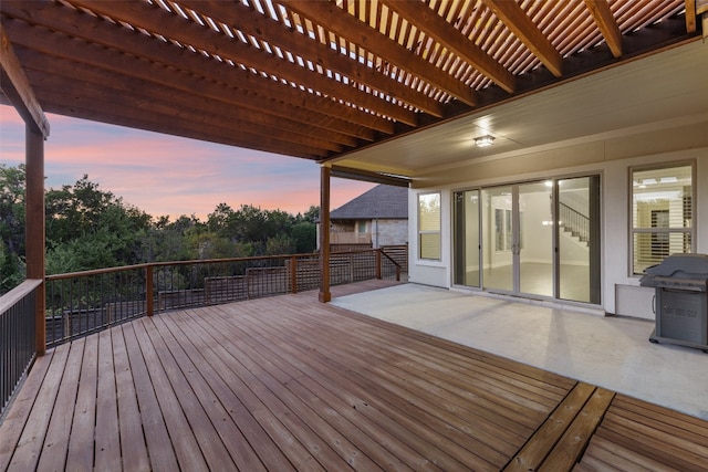 deck at dusk with a pergola and grilling area