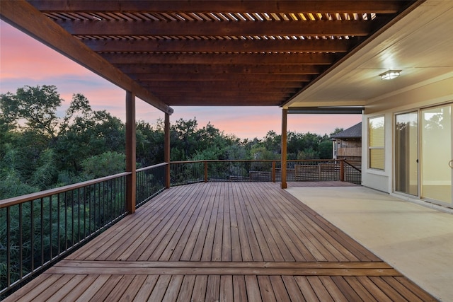 deck at dusk featuring a pergola