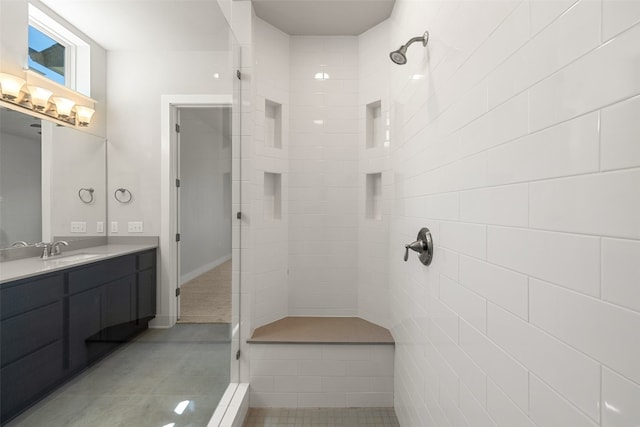 bathroom featuring vanity, a tile shower, and tile patterned floors