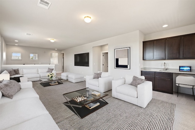 living room featuring light colored carpet and sink