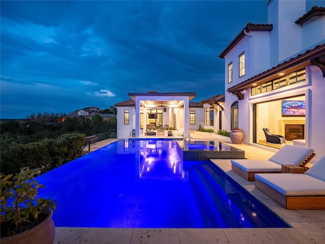 view of swimming pool featuring an in ground hot tub, a patio, and an outdoor structure