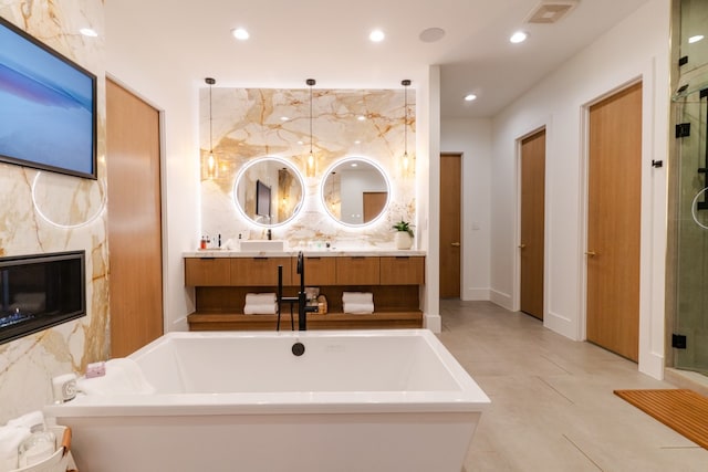 bathroom with a stall shower, visible vents, a high end fireplace, a freestanding tub, and recessed lighting