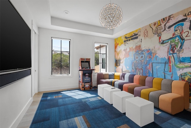 interior space featuring hardwood / wood-style flooring, a raised ceiling, and a notable chandelier