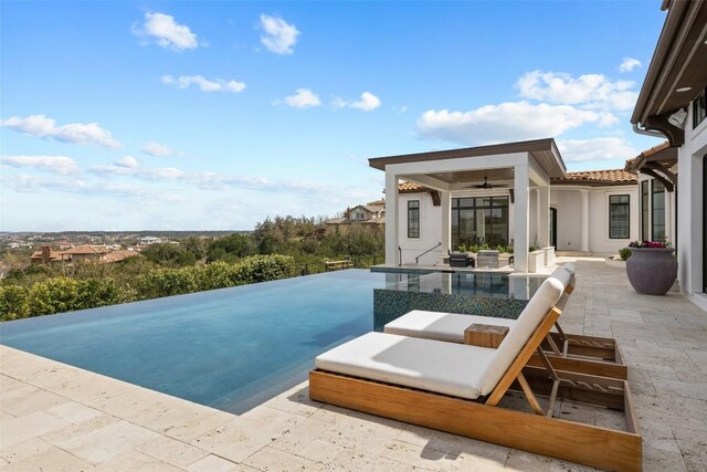 view of pool with ceiling fan and a patio area