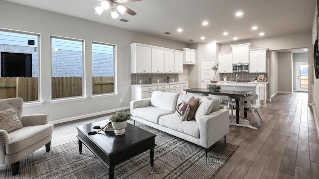 living room with ceiling fan, sink, and hardwood / wood-style floors