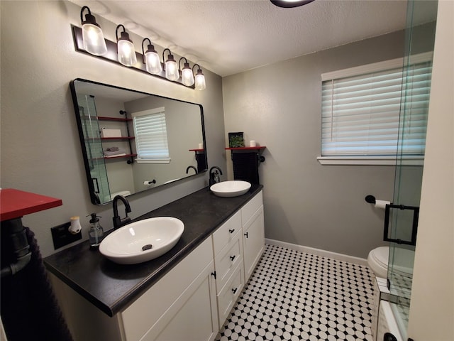 bathroom with toilet, vanity, and a textured ceiling