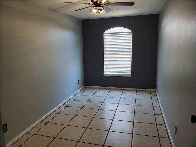 tiled spare room featuring ceiling fan