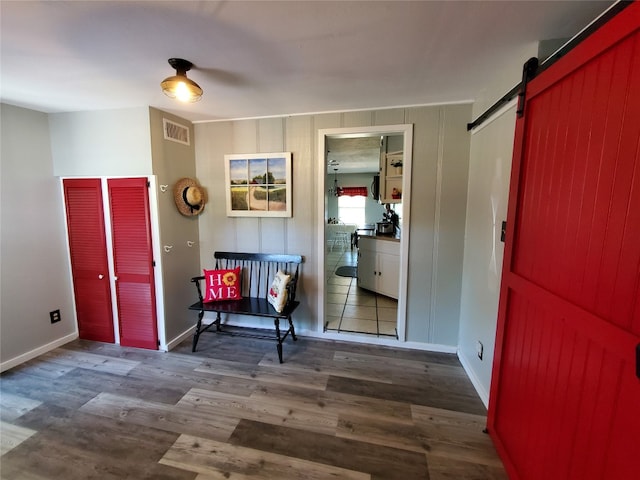 entrance foyer with a barn door and dark hardwood / wood-style flooring