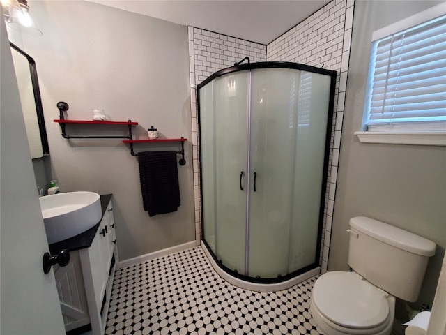 bathroom featuring vanity, toilet, and an enclosed shower