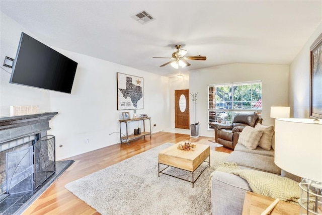 4316 Campo Verde Dr, Austin, TX 78749 - living area with wood finished floors, ceiling fan, vaulted ceiling, and a fireplace with raised hearth