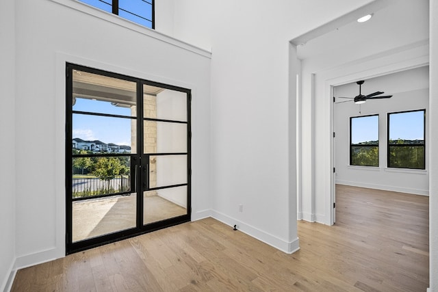 foyer entrance featuring light hardwood / wood-style flooring, a wealth of natural light, and ceiling fan