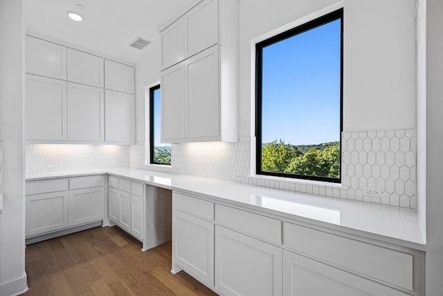 kitchen featuring backsplash, white cabinetry, and dark hardwood / wood-style flooring