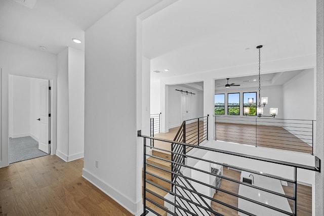 hallway featuring a notable chandelier and hardwood / wood-style flooring