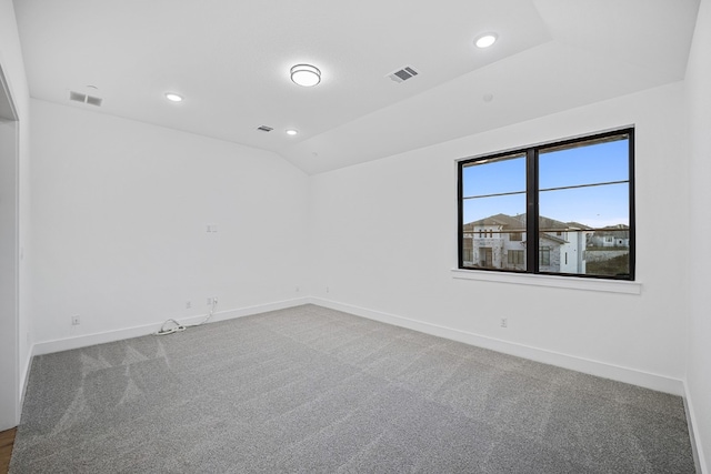 carpeted empty room with lofted ceiling