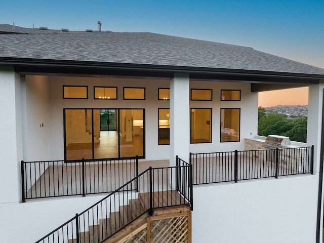 back house at dusk with a balcony