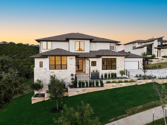 view of front of property featuring a garage and a lawn